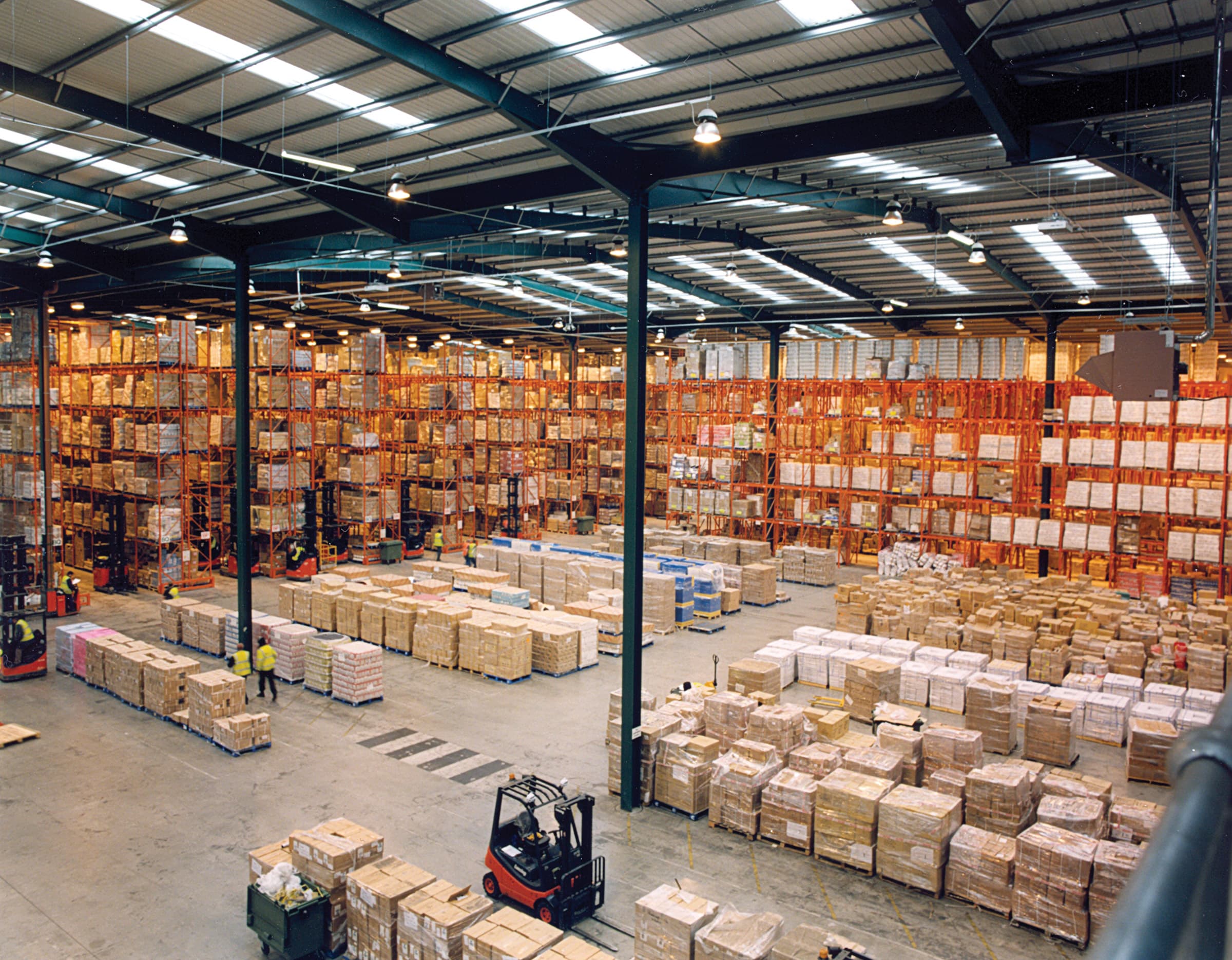 Warehouse staff and forklifts actively receiving and staging palletized freight